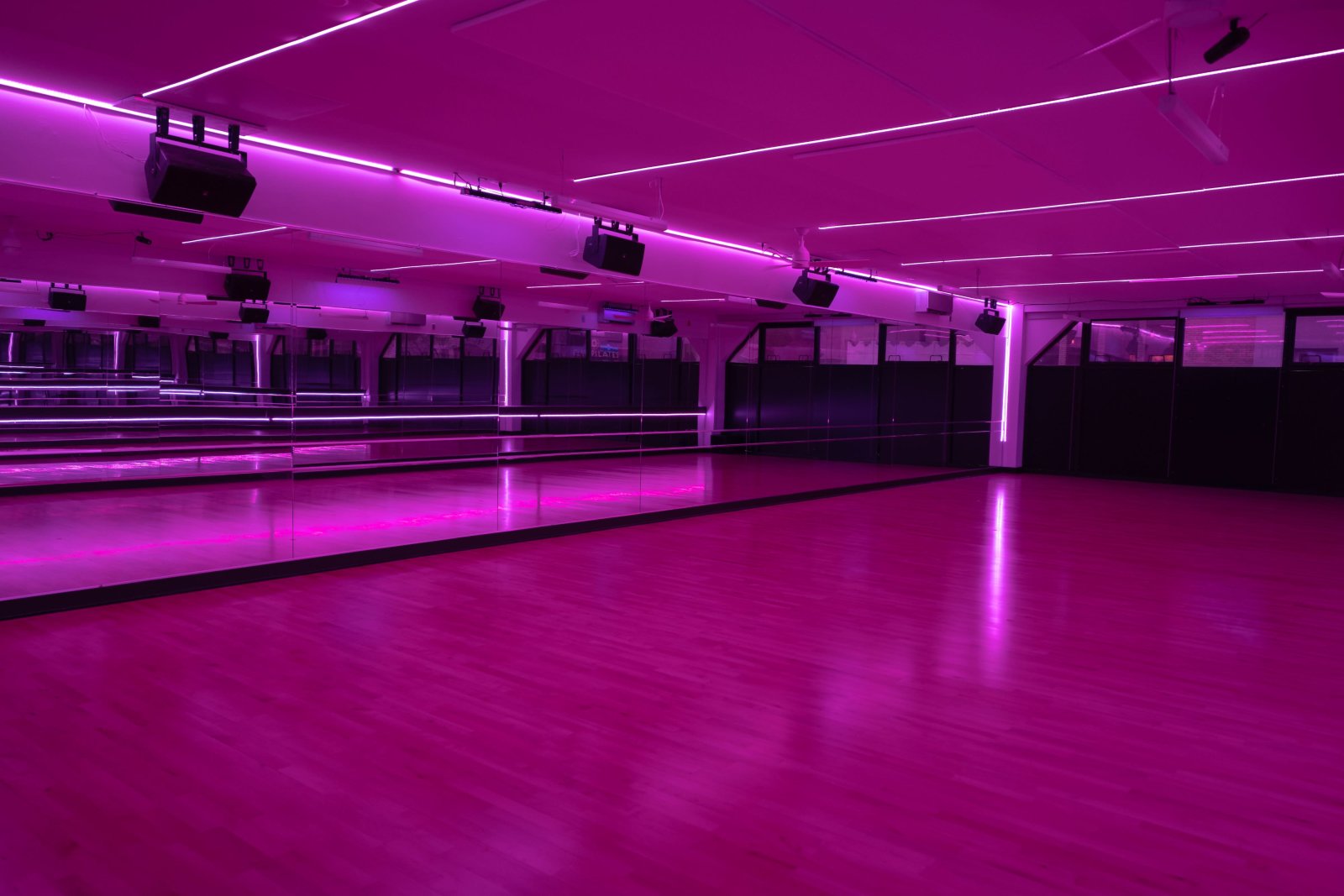Pink-lit dance floor at 305 Fitness Philly with mirror wall